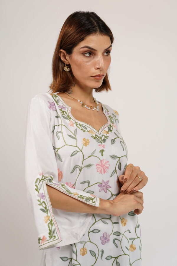 Close-up of intricate floral Aari embroidery on the neckline of VaadiByLiza’s white floral kurta set.
