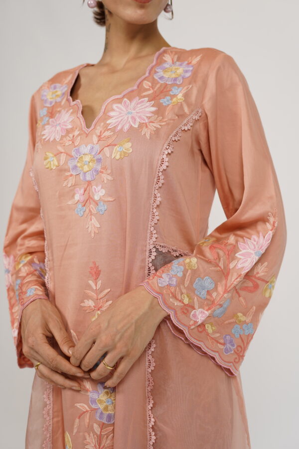 Close-up of Aari embroidery on the neckline and sleeves of VaadiByLiza’s Lady Tulip Kalidar Kurta Set in salmon peach.