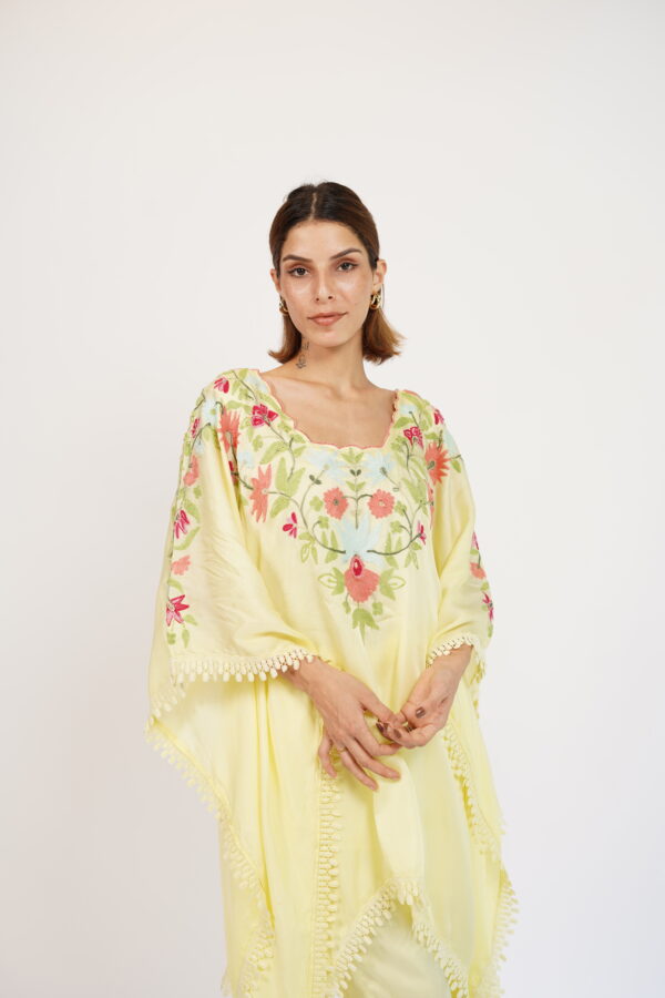 Full-length view of a pastel yellow embroidered silk kaftan set with matching bottoms.