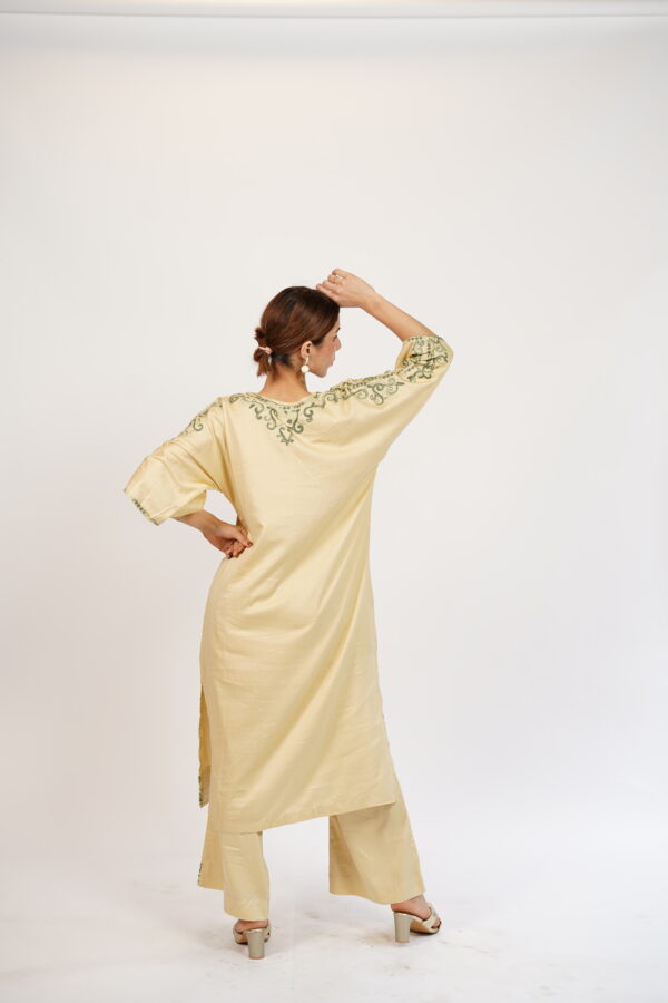 Back view of a beige kaftan-style kurta with subtle embroidery on the shoulders.